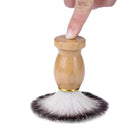 Shaving brush with wooden handle and black and white bristles on a white background