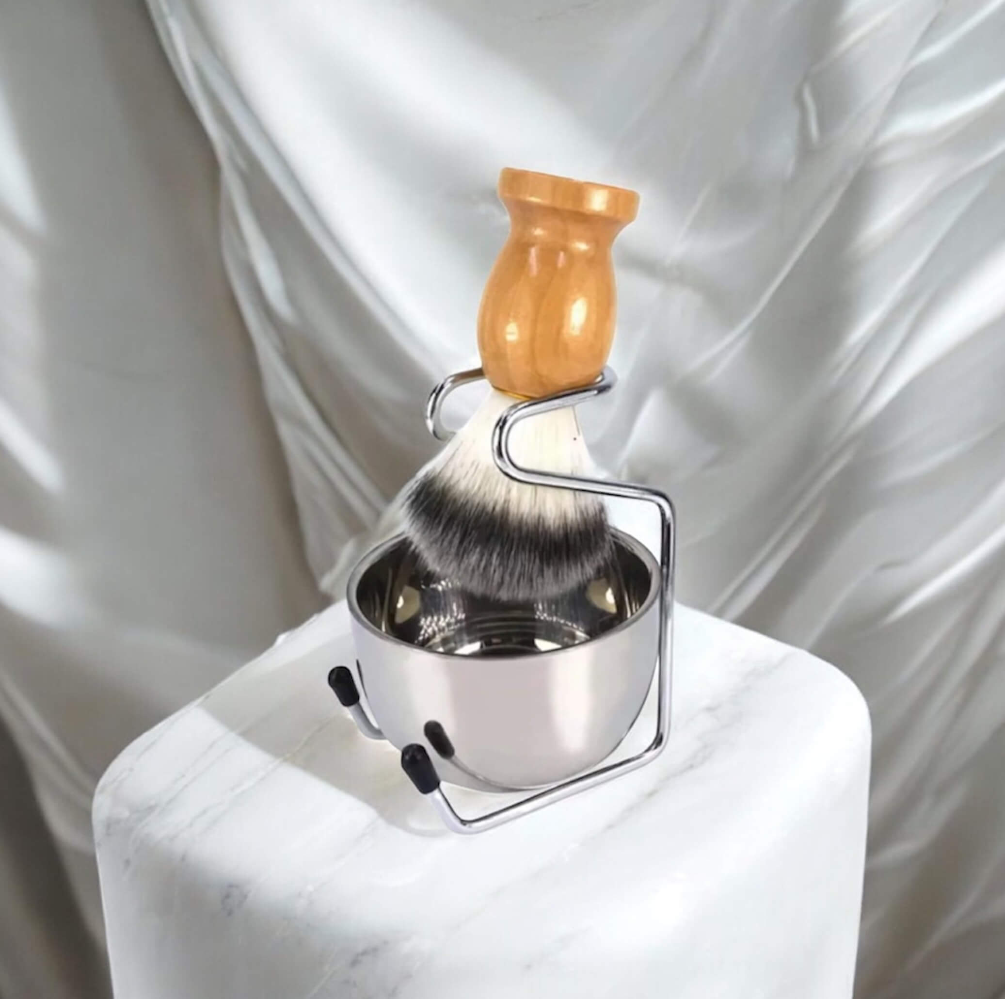 Shaving brush with wooden handle and metal stand on a white background