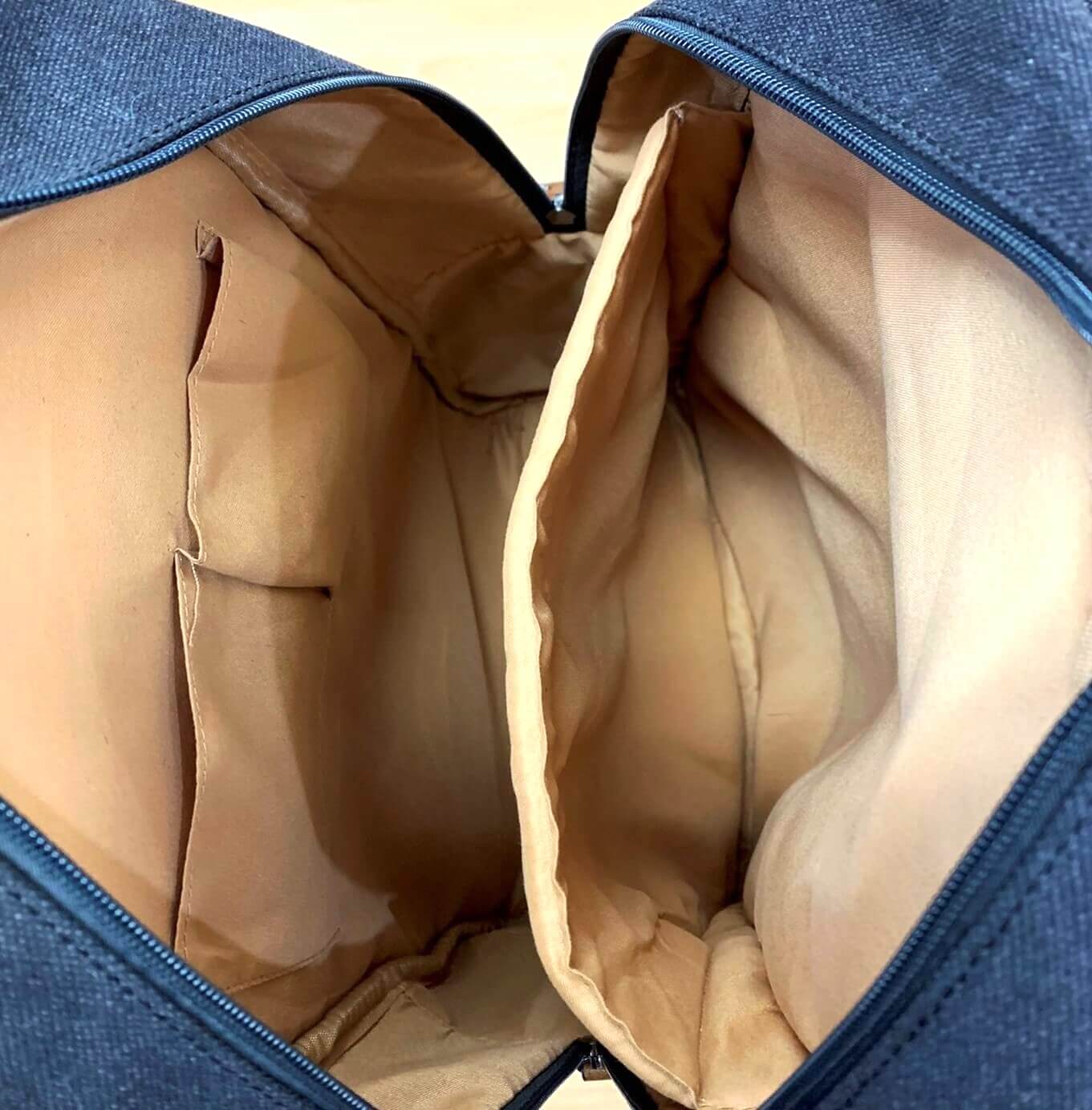 Close-up of a black garment bag with beige interior